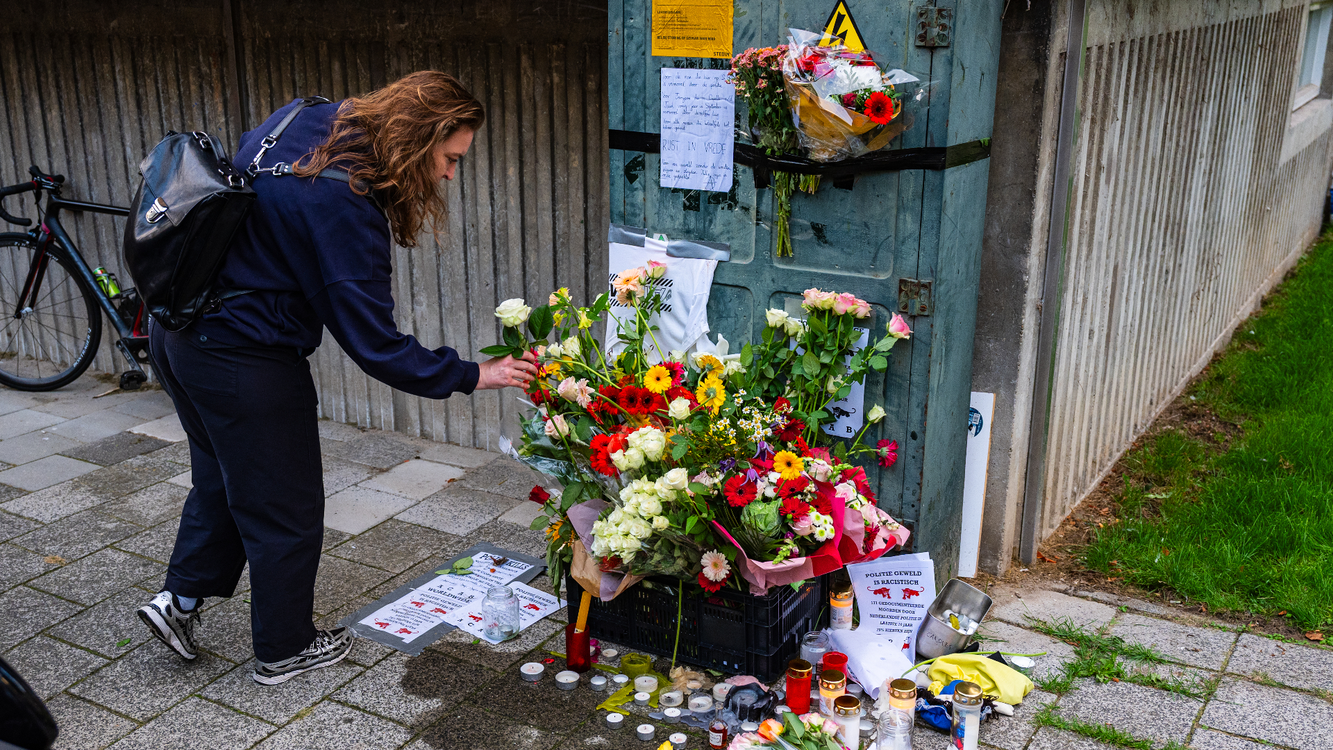Vrouw legt bloemen neer op gedenkplek voor Alfredo.