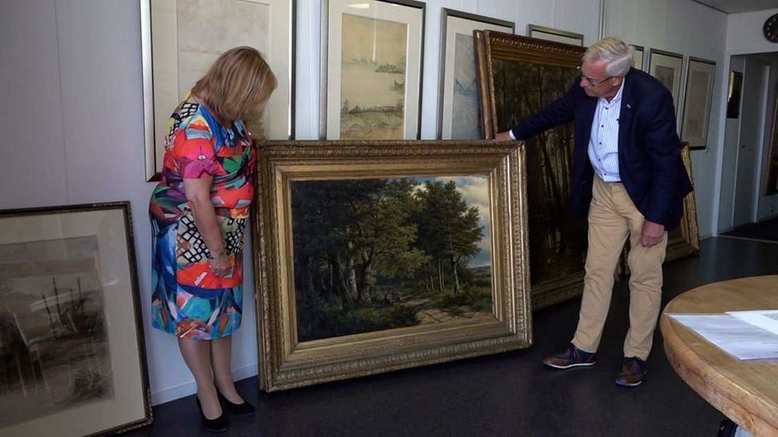 Wethouder Rolink en bemiddelaar Tirion bekijken een schilderij uit de collectie van Pim Kwak