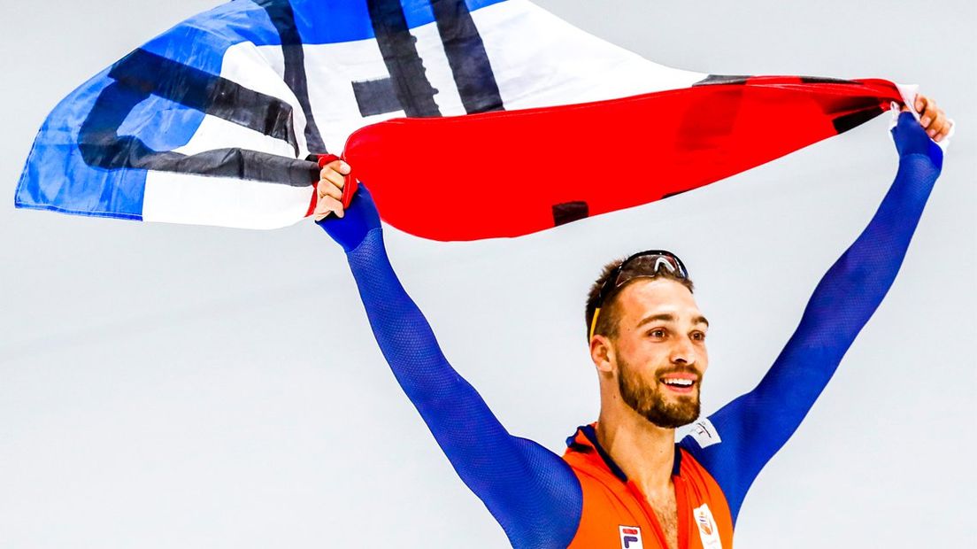 Kjeld Nuis viert zijn tweede olympische titel met de Nederlandse vlag.