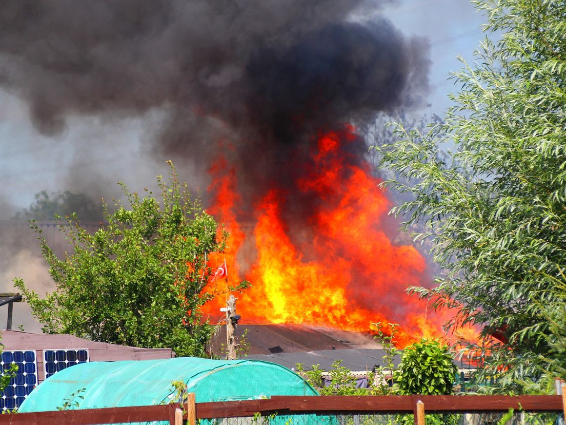 De brand woedt op een volkstuinencomplex.