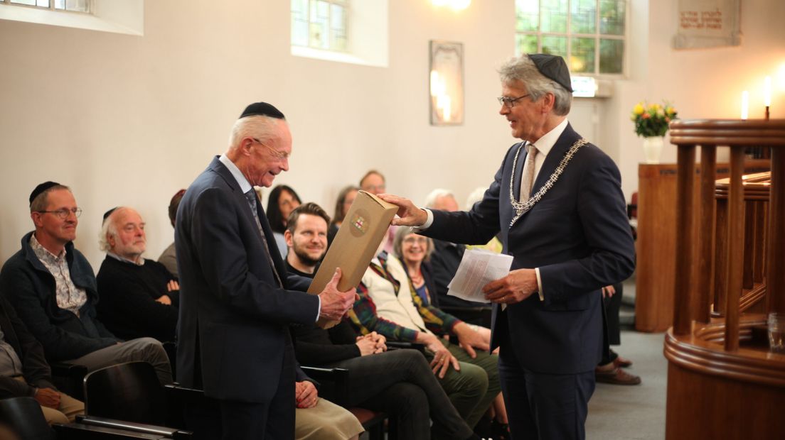 BurgemeesterBolsius (rechts) overhandigt een cadeau aan priester Frans Zwarts in de synagoge in de binnenstad.