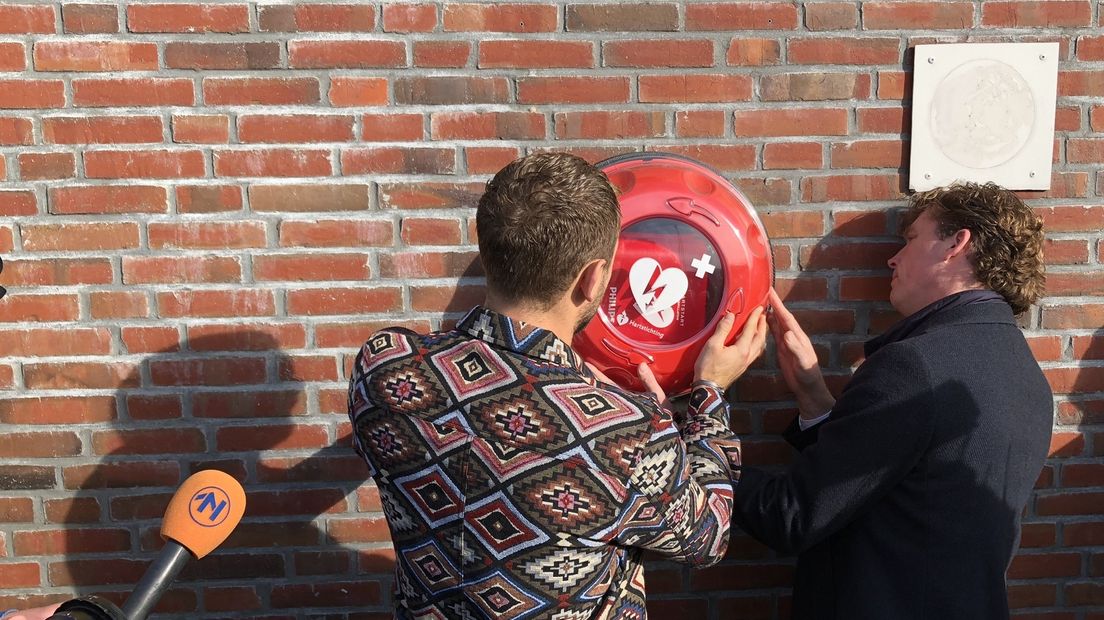 Jeroen Zoet hangt de AED samen met wethouder Henk-Jan Schmaal op