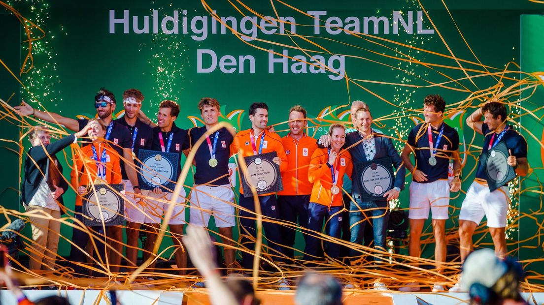 De Nederlandse roeiers en wielrenners met hun medailles op het podium