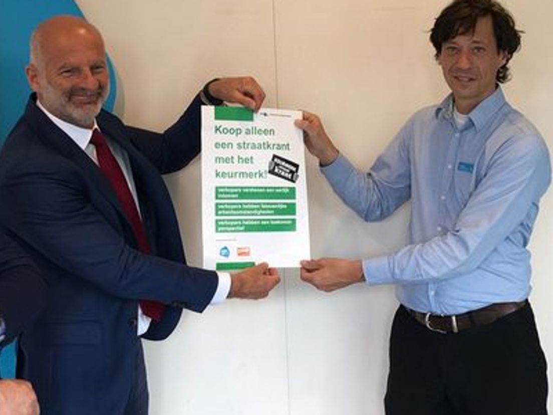 Wethouder Schneider hangt de eerste poster op