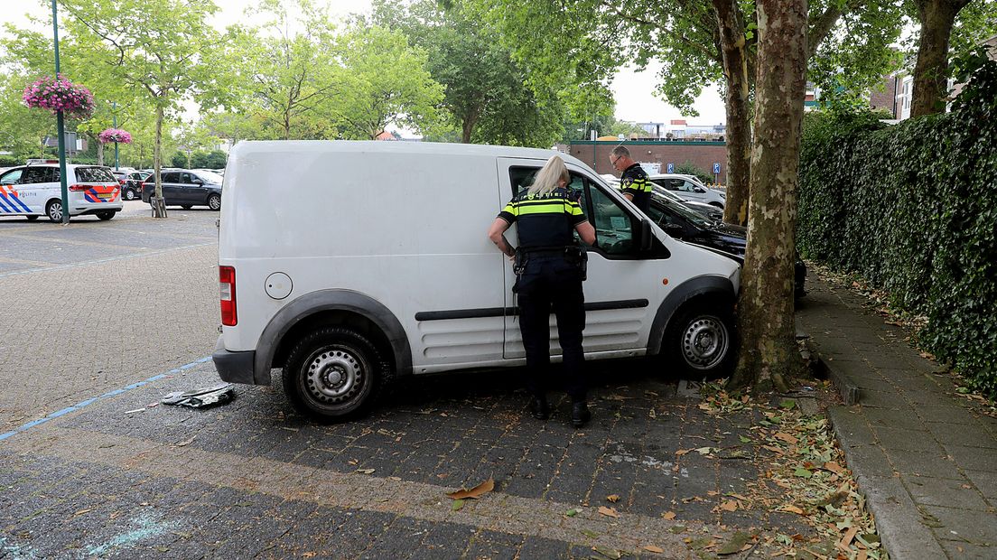 De bestelbus is scheef over de parkeerplaats tegen een boom gereden en zo achtergelaten.