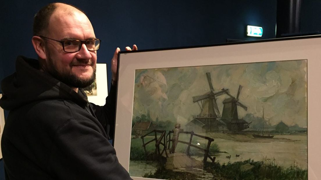 Frans Vleeshouwer met een origineel schilderij van Jan Kruis in z'n handen.