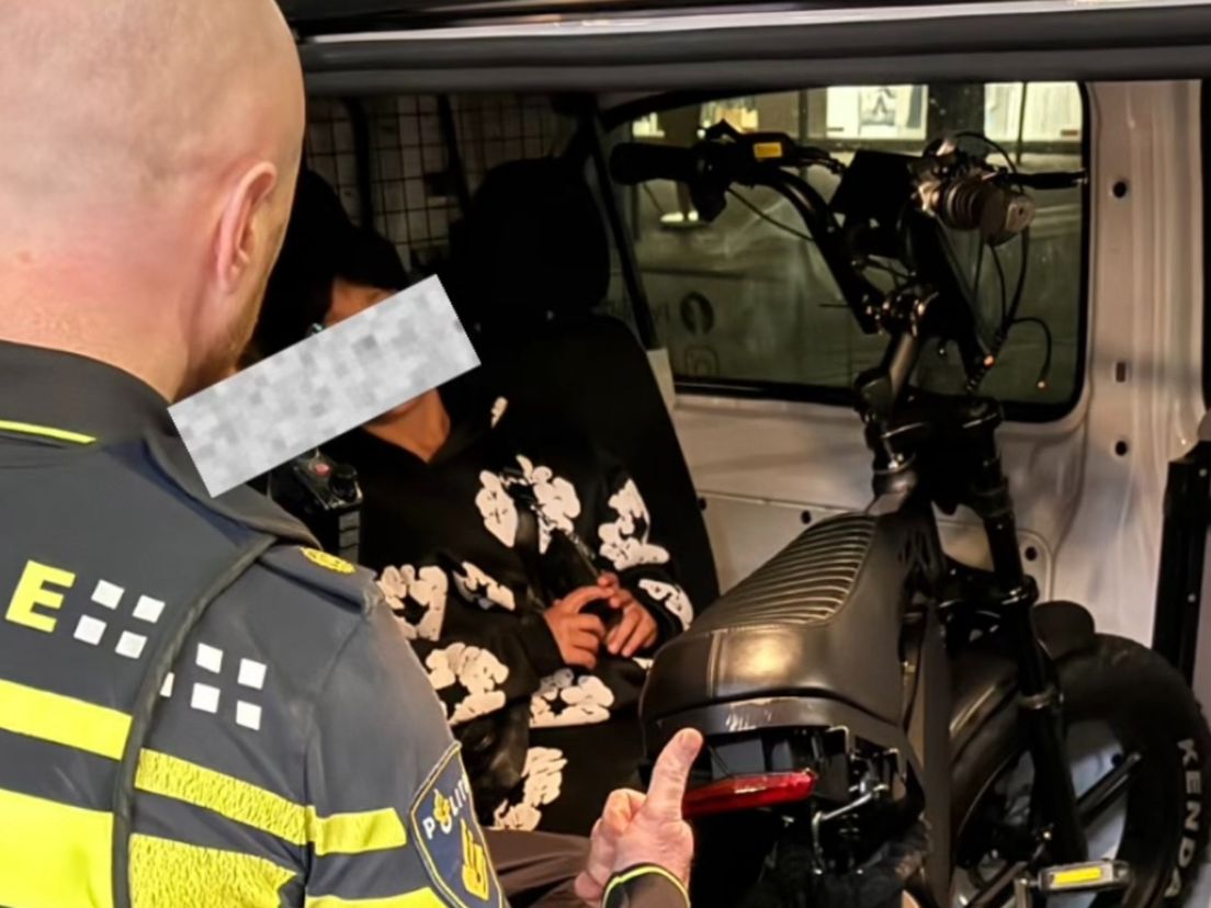 Verdachte zit na het opsteken van de middelvinger in de politiebus