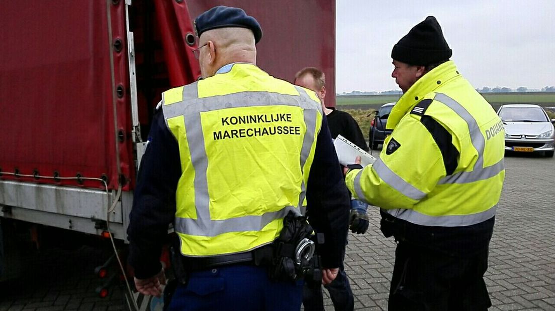 De Marachaussee controleert een vrachtwagen van mensensmokkelaars
