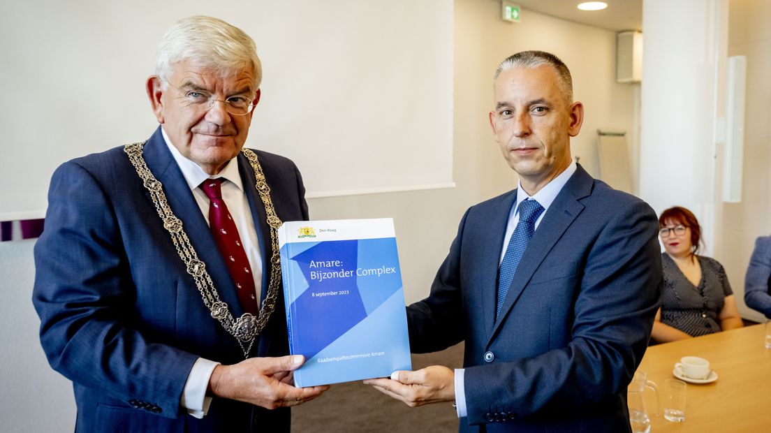 Burgemeester Jan van Zanen (l) ontvangt een rapport van Arjen Dubbelaar, voorzitter van de raadsenquêtecommissie Amare, met daarin de toelichting op het onderzoek en de bevindingen van het rapport van de raadsenquêtecommissie Amare