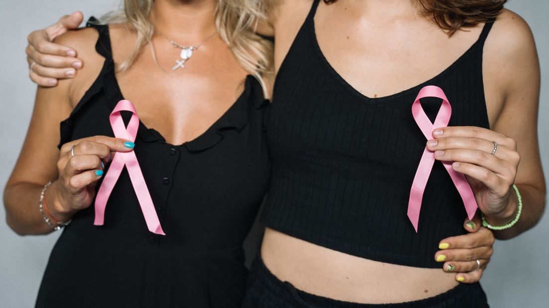 Twee vrouwen tonen het symbool van borstkanker