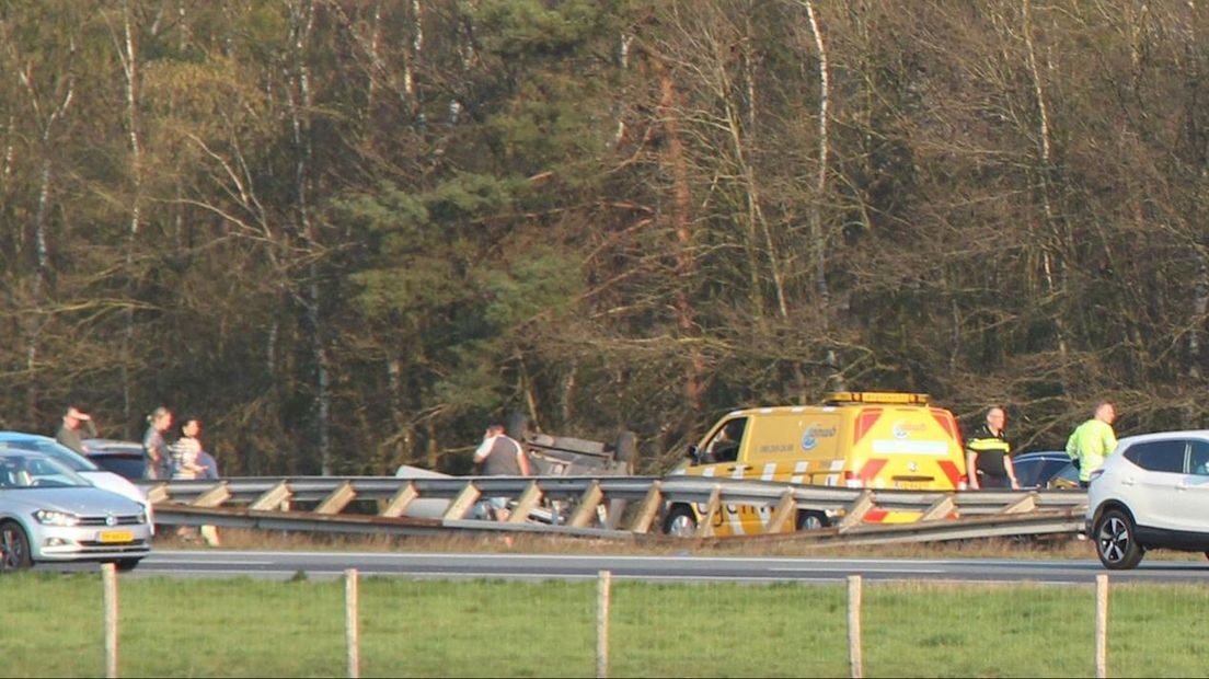 Auto ligt op de kop naast de snelweg