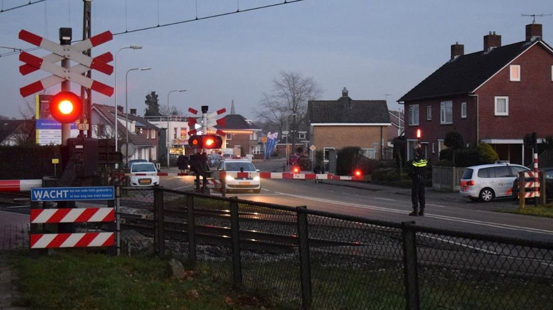 Een agent houdt de situatie bij een overweg in de gaten