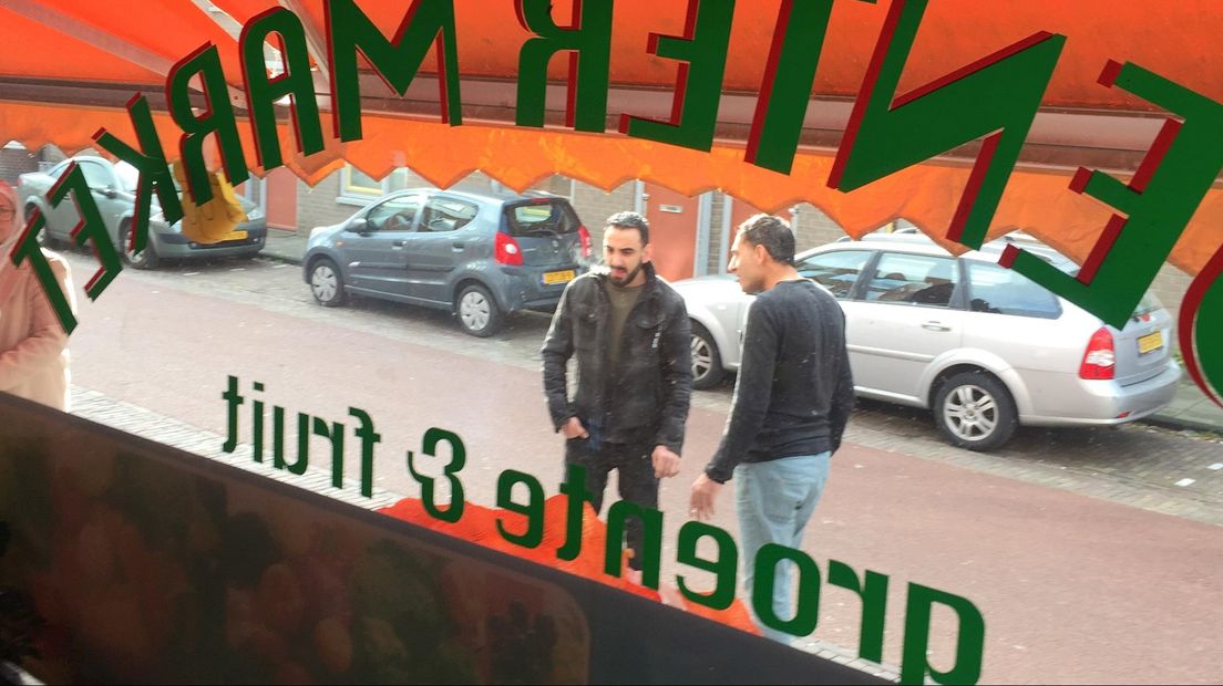 Azad Khalaf (rokend) voor zijn winkel aan de Deventer Rielerweg