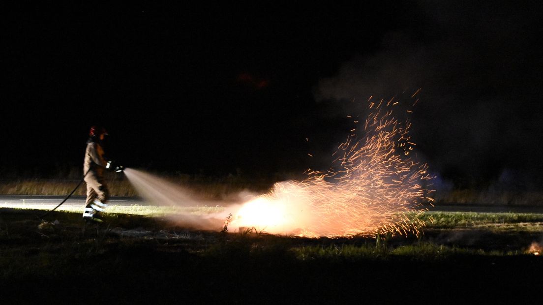 De brandweer blust de brand bij het Postdijk-viaduct over de A7