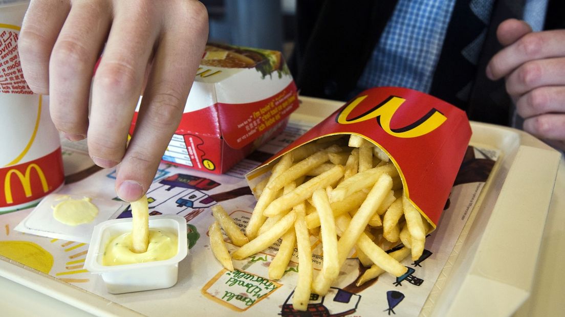 Een man verorbert een maaltijd van McDonalds