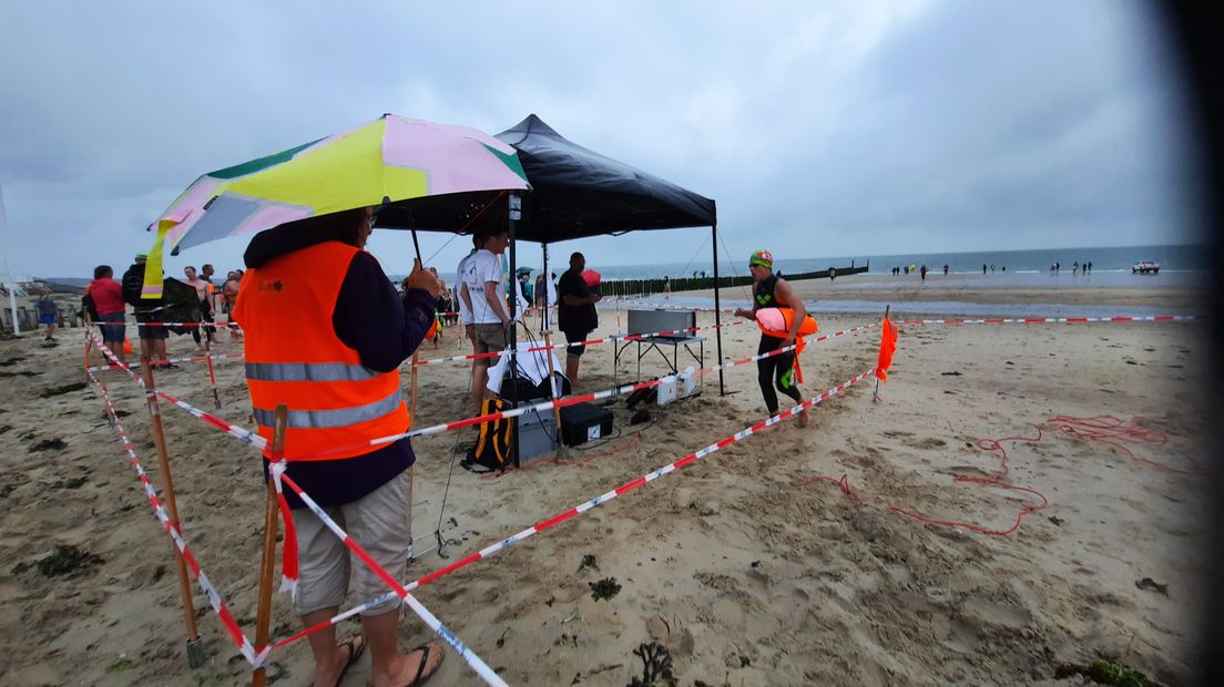 Een van de deelnemers bij de finish op een kletsnat strand bij Zoutelande