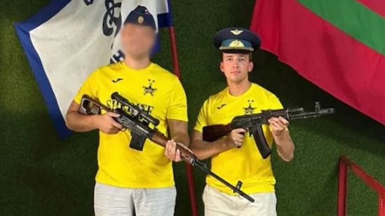 Wethouder Tom de Nooijer laat zich fotograferen met pro-Russische vlag en kalasjnikov