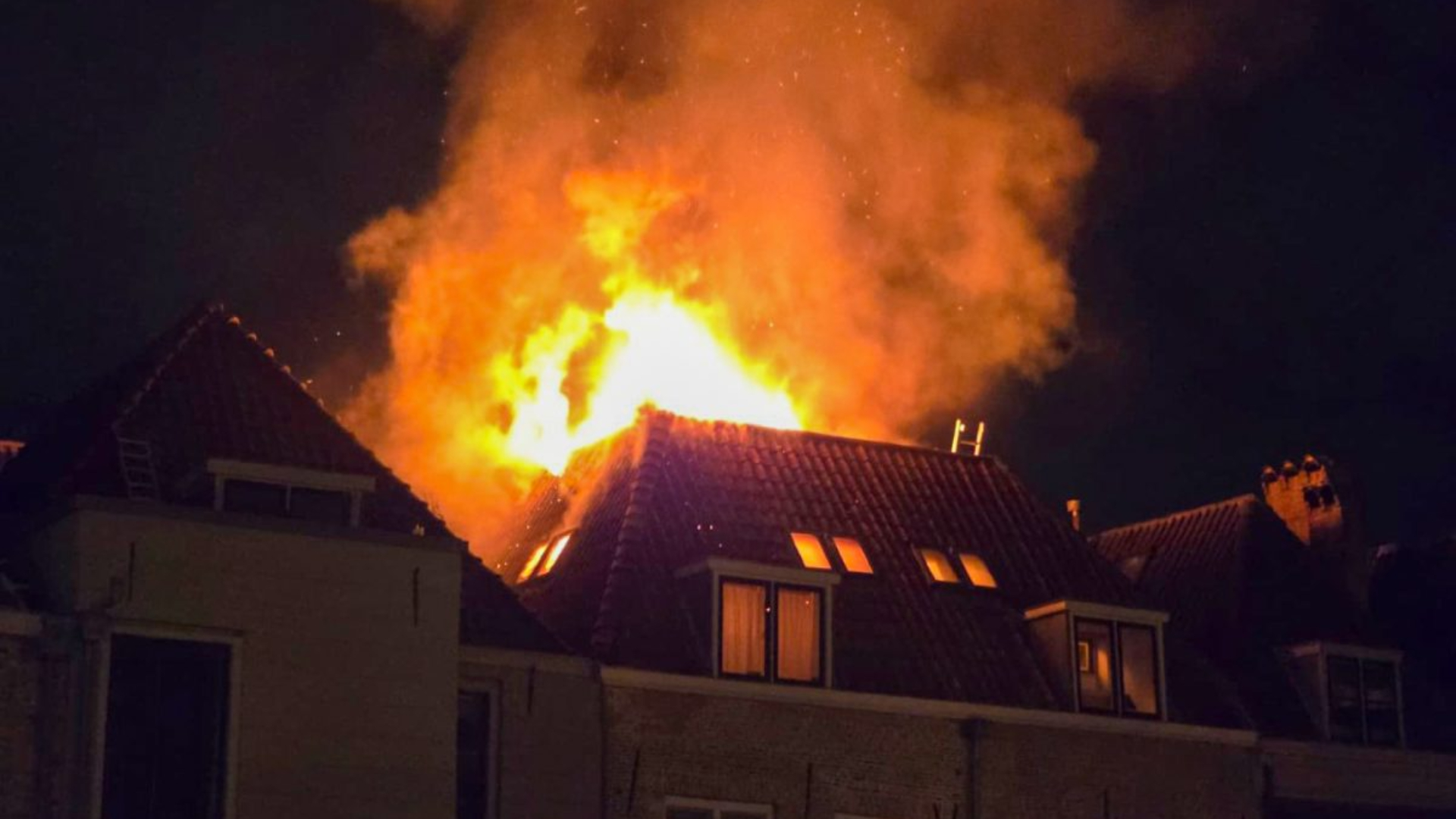 De vlammen slaan metershoog uit de woning in het centrum van Dordrecht