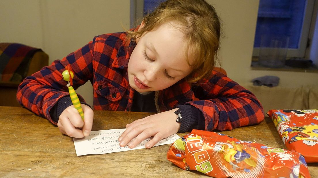 Een kind schrijft een sinterklaasgedicht. Foto ter illustratie.