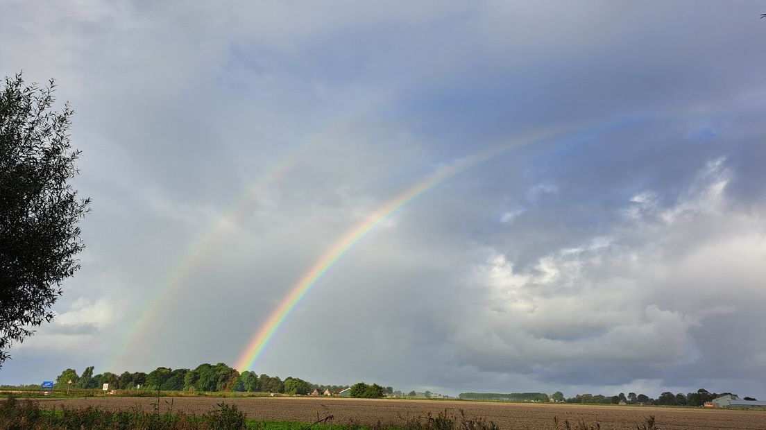 Mooie wolken met dubbele regenboog