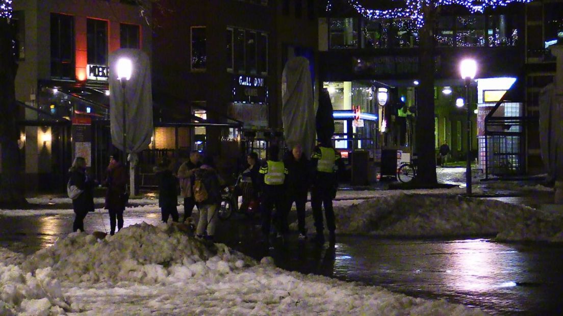 De politie spreekt een groepje mensen aan in Enschede