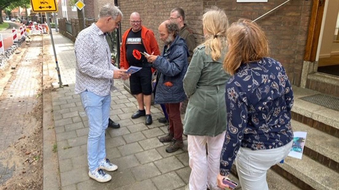 Radiomaker Eric van den Berg (links) praat buiten met de actiegroep.