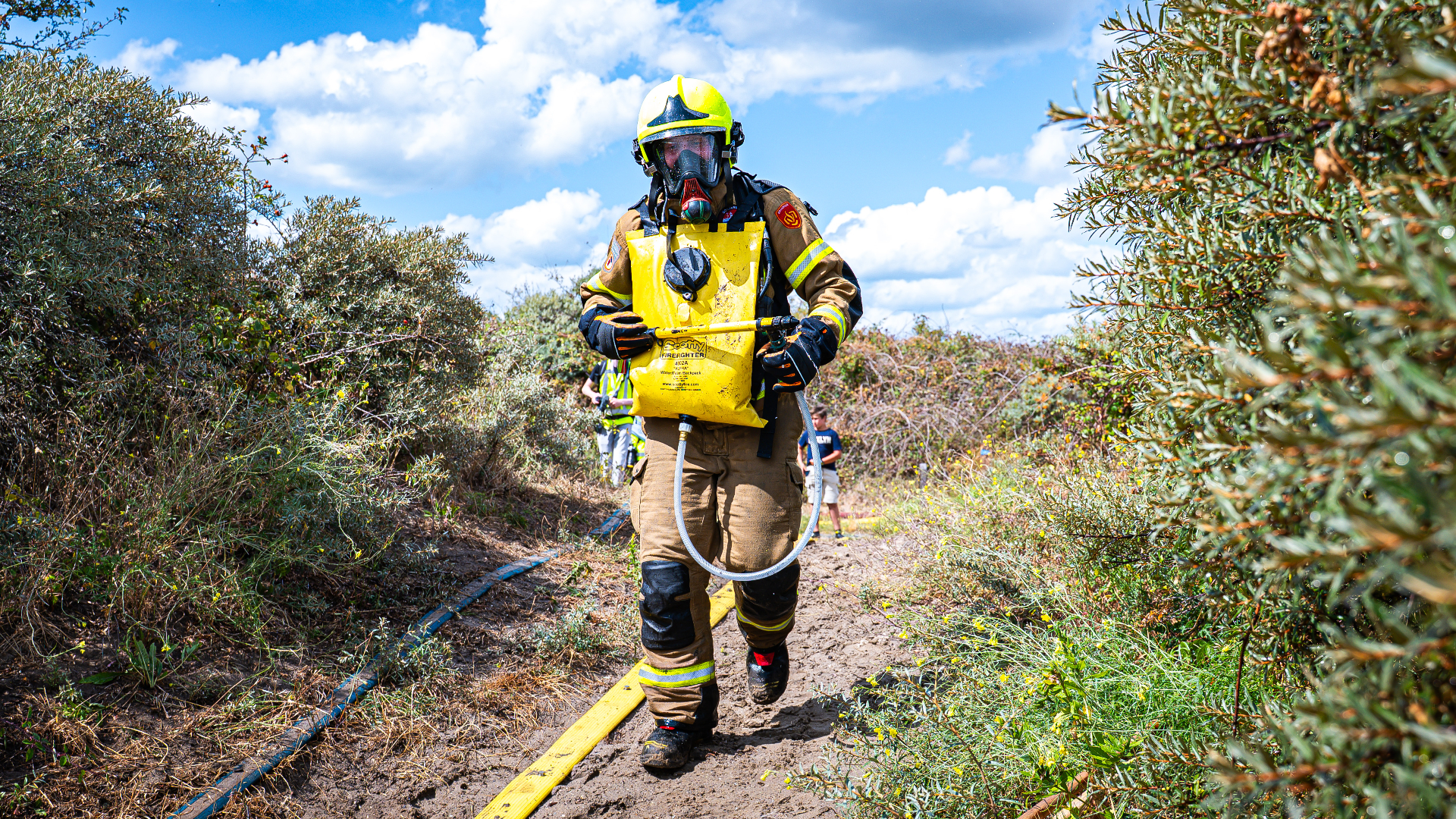 Brandweerman met bluszak in het duingebied