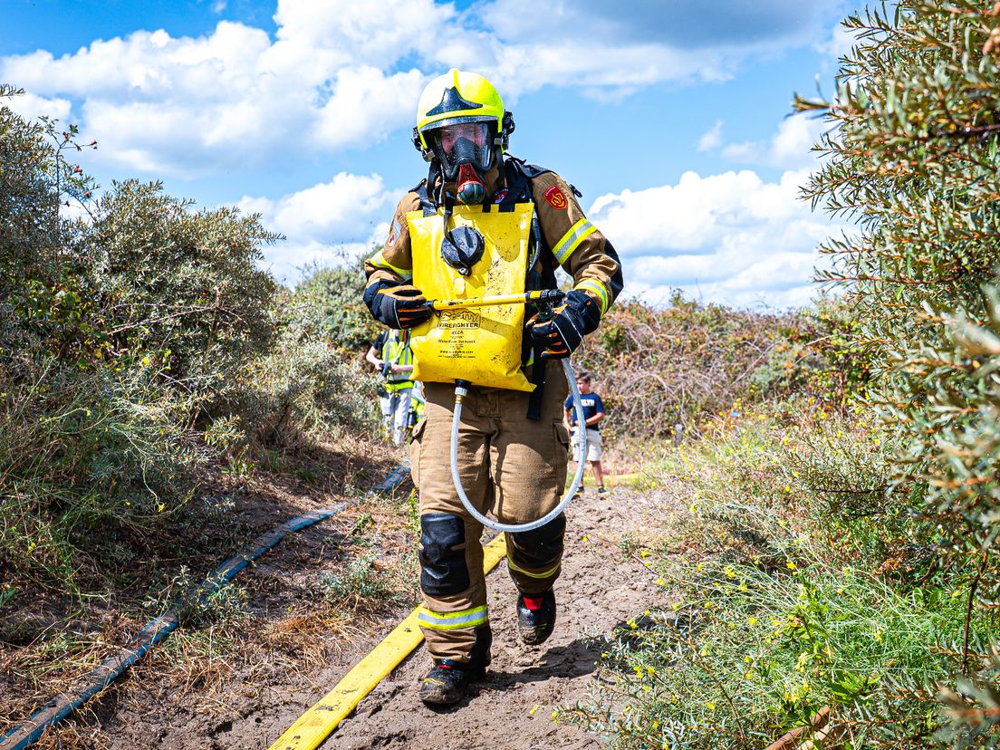 Brandweerman met bluszak in het duingebied