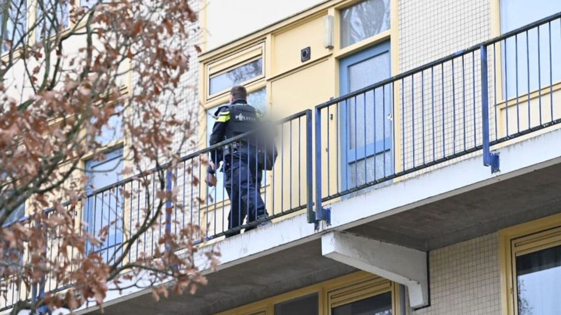 De politie houdt een man aan bij de flat.