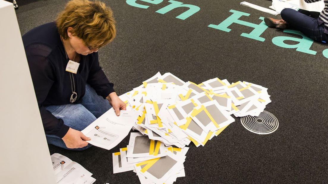 Een vrouw telt de stemmen van het referendum in Den Haag