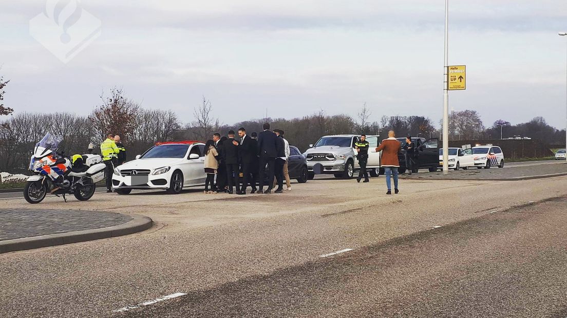 De trouwstoet wordt aan de kant gezet door de politie.