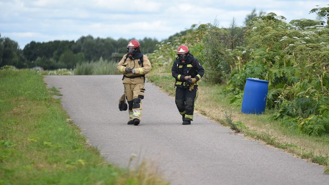 De brandweer inspecteert het vat