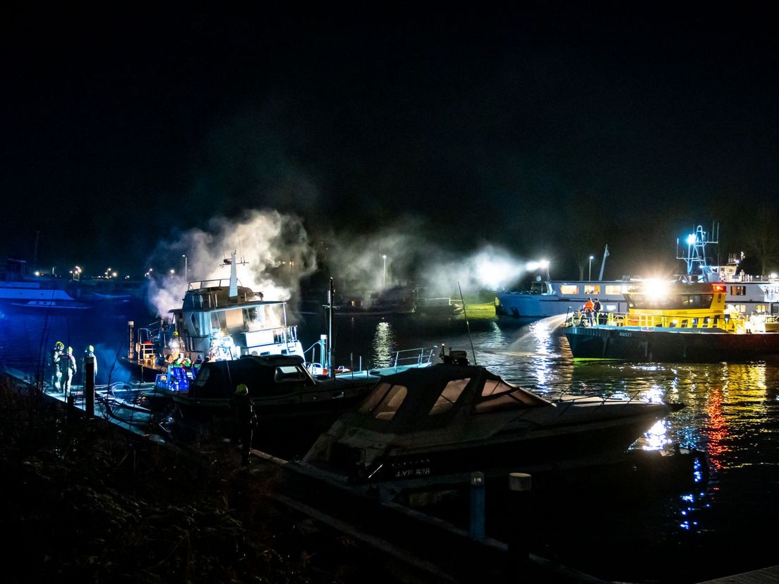 Brand aan de Veerweg in Hellevoetsluis, links het plezierjacht, rechts het opvangschip met asielzoekers