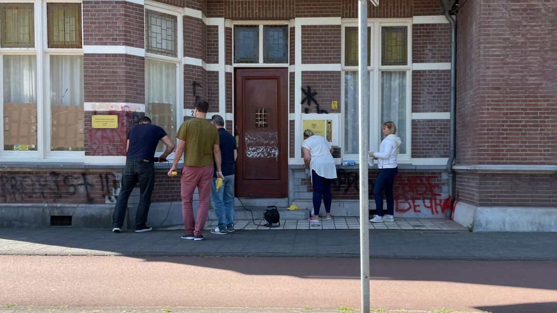 Zondagochtend probeert het personeel van de ambassade de graffiti te verwijderen