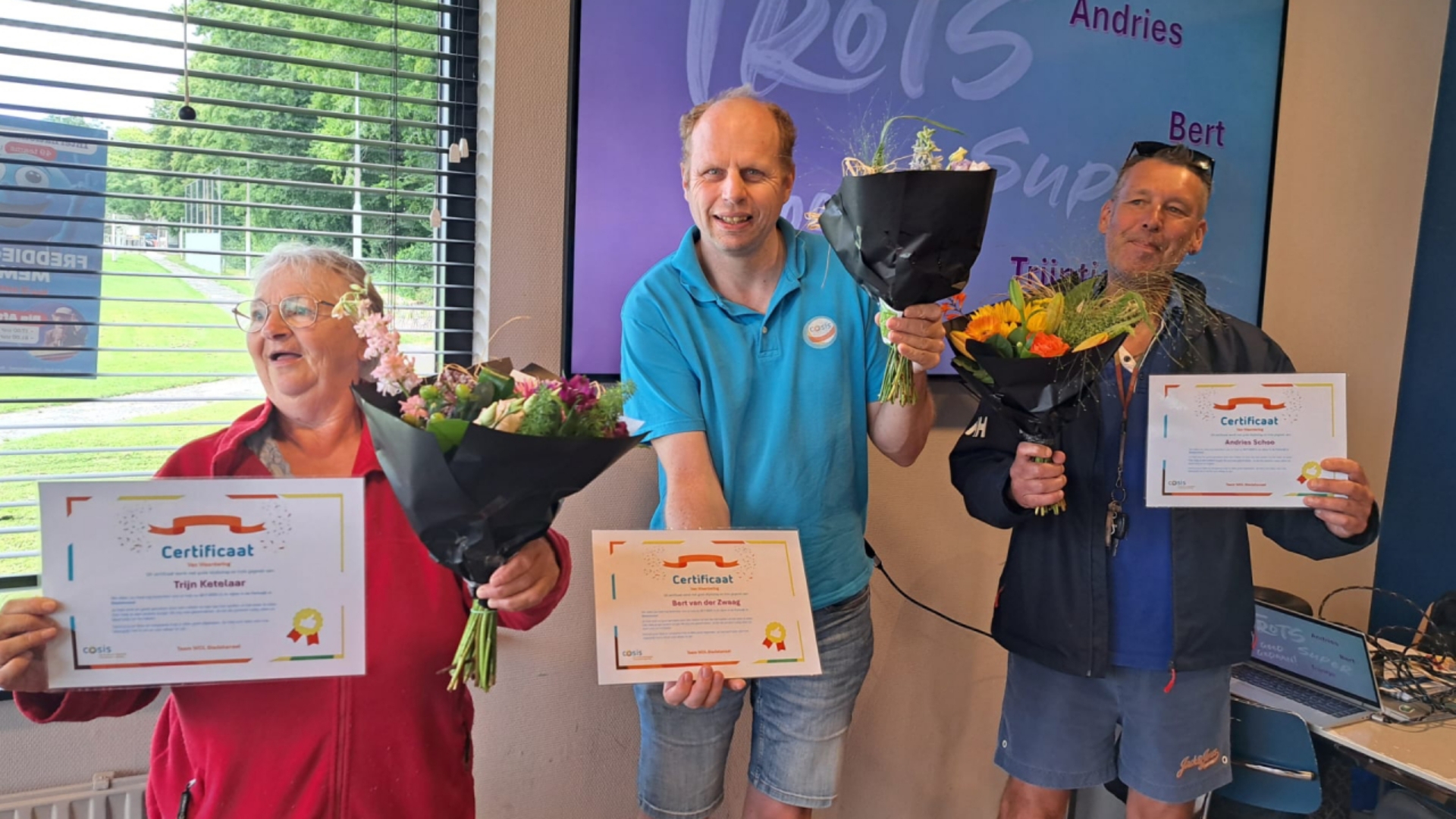 Trijn, Bert en Andries met bloemen en een certificaat