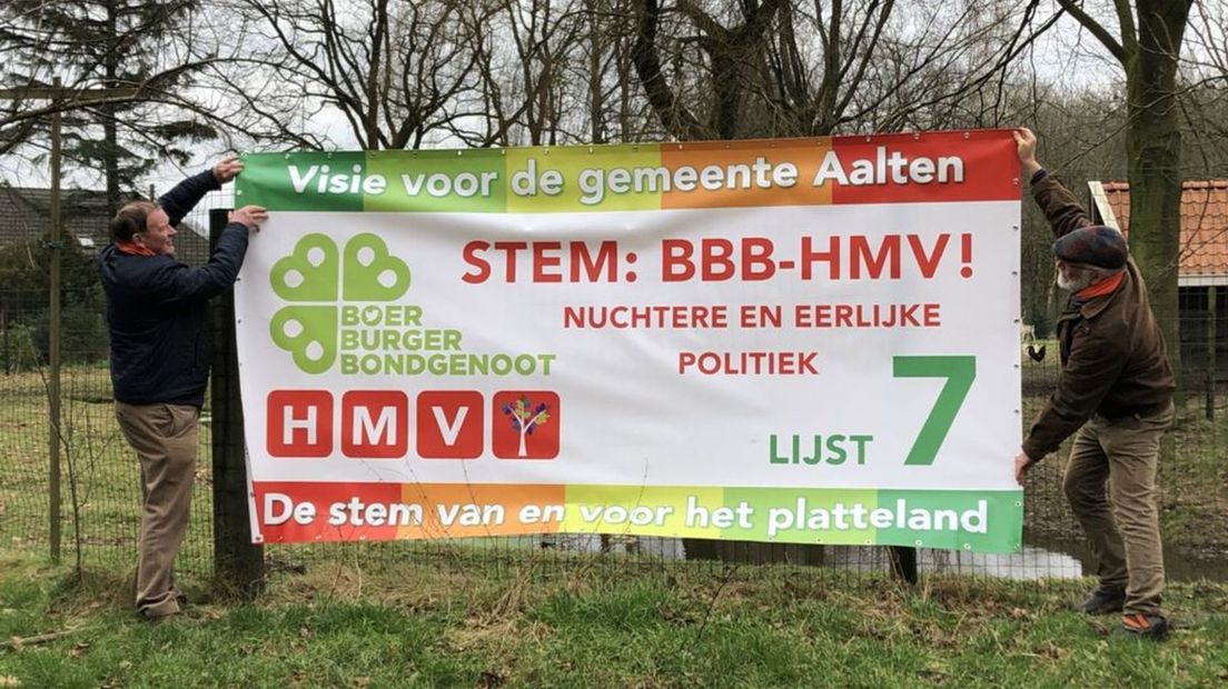Henk Meerdink (links) hangt banner BBB-HMV op.
