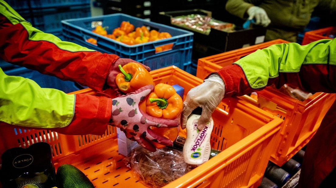 Vrijwilligers pakken een pakket voor de voedselbank in