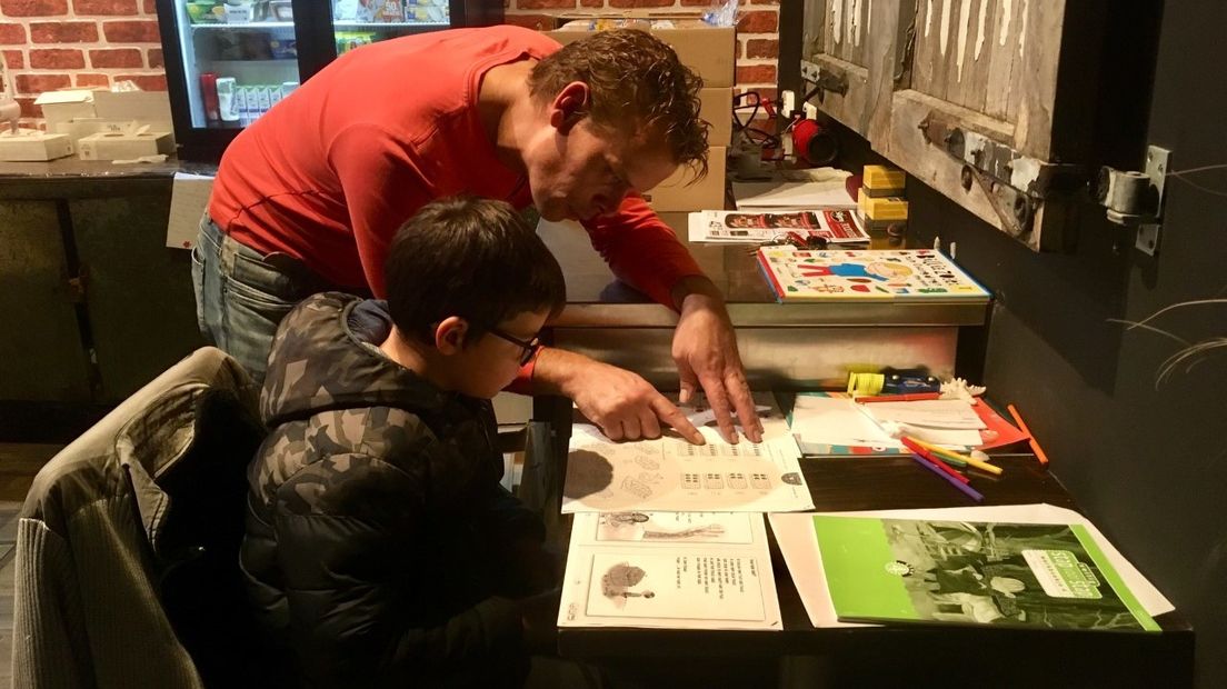 Achterin de winkel zit de 7-jarige Leroy die zijn huiswerk maakt onder begeleiding van zijn vader Jason Lockefeir.