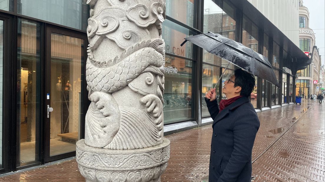 Chang Wong bewondert het beeldhouwwerk van de toegangspoort in Chinatown