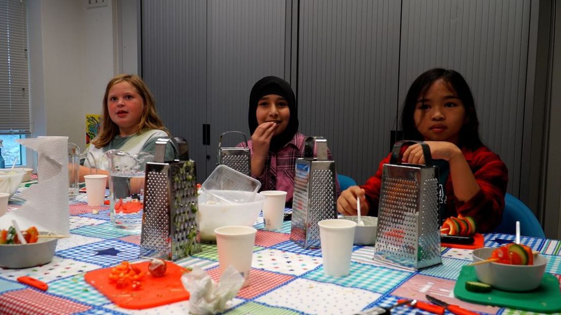 Kinderen leren koken tijdens het verlengde leertijdprogramma.