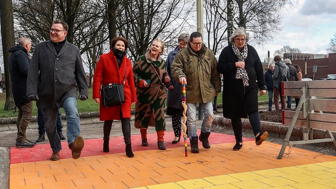 De initiatiefnemers lopen samen met de wethouder over het nieuwe regenboogdpad