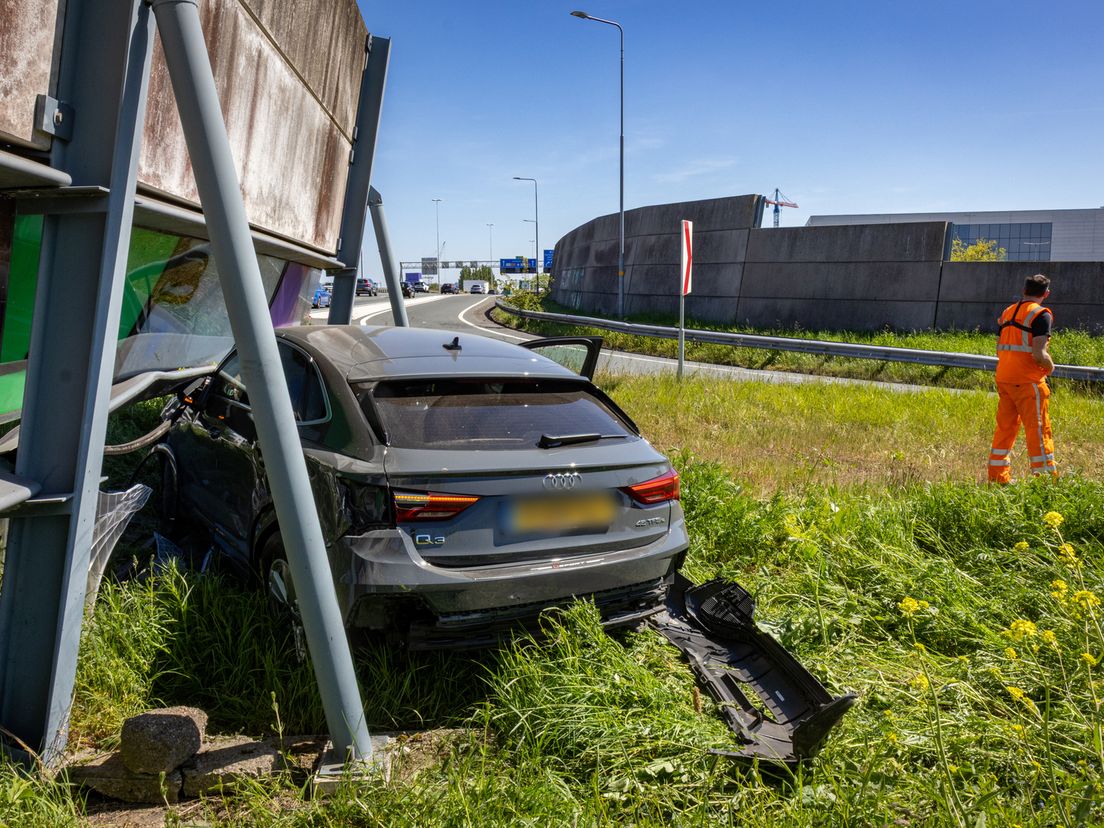 De auto kwam onder de geluidswand tot stilstand.