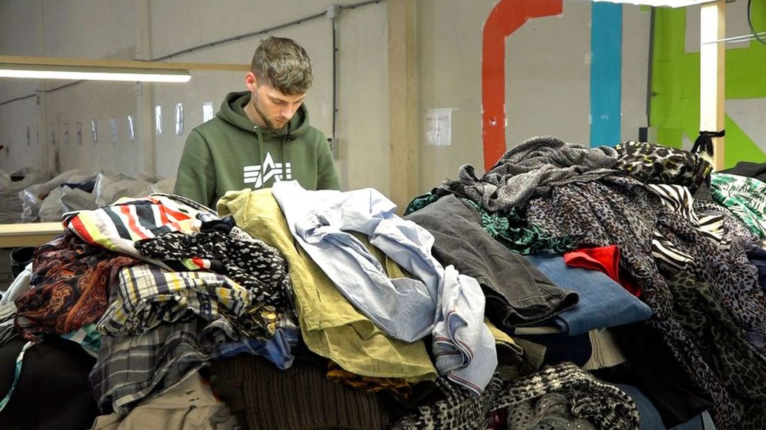 Mike van der Meulen sorteert kleding.