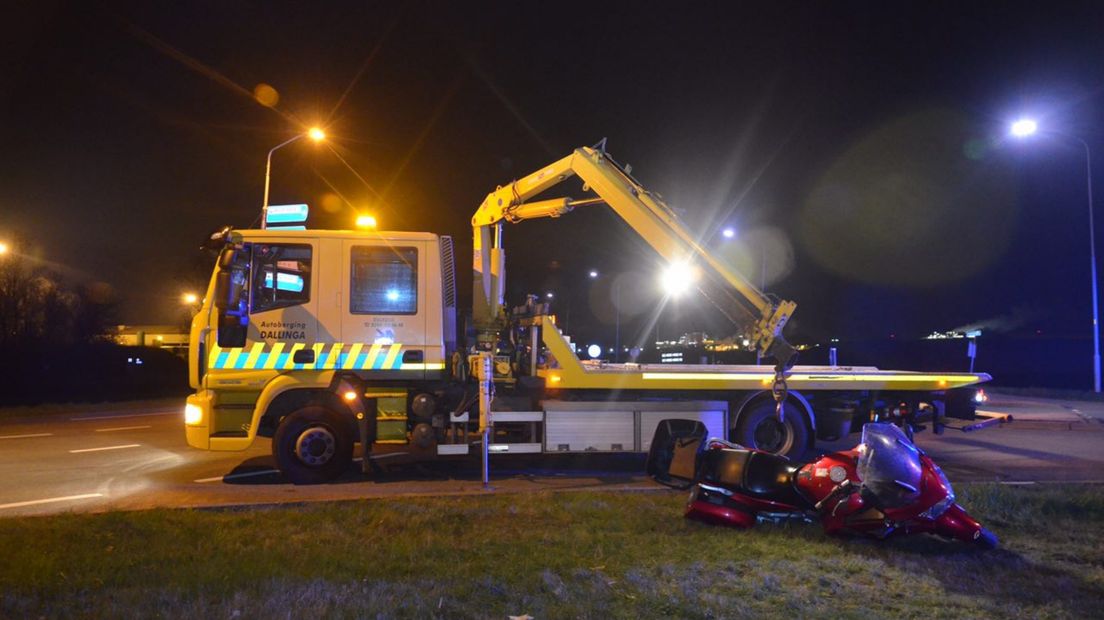 Een motor wordt na een ongeval door een berger afgevoerd (archief)