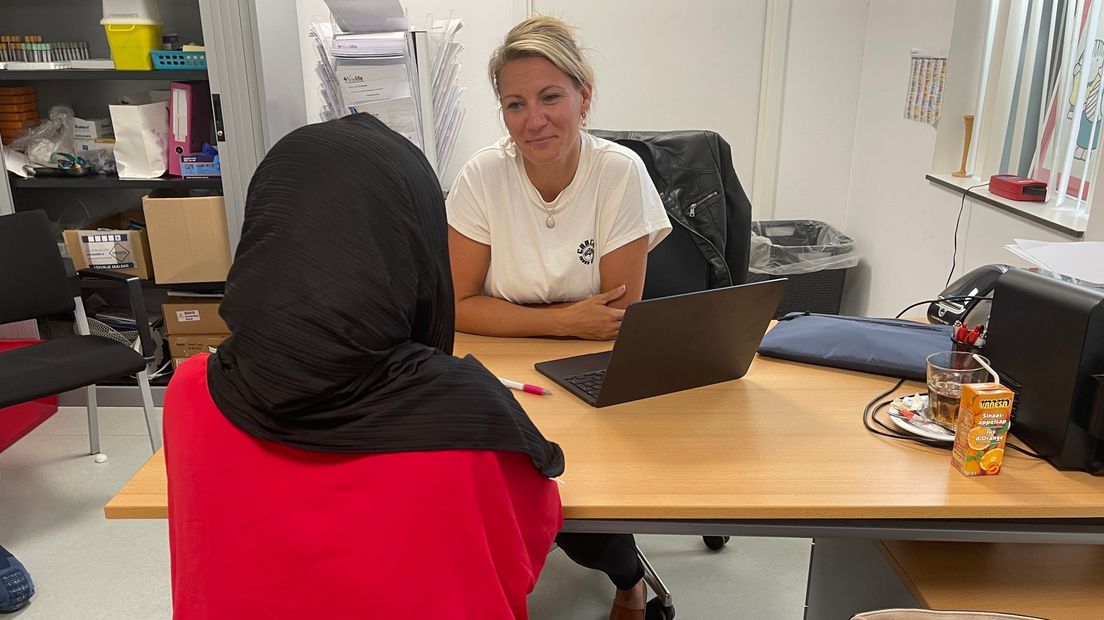 Rebecca Nott in gesprek met een zwangere vrouw in het azc van Ter Apel