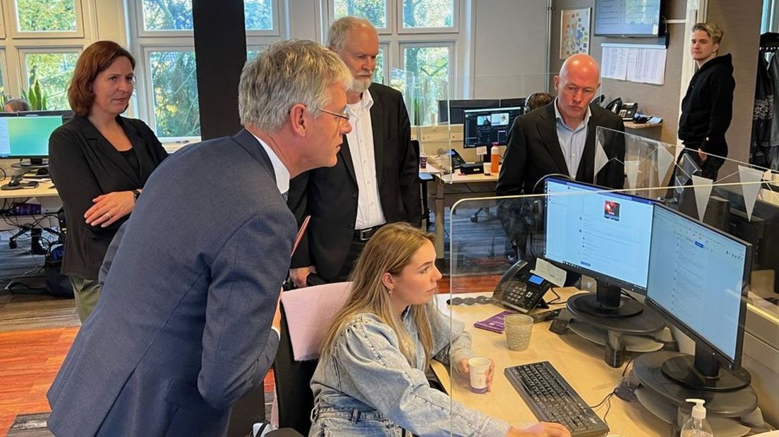 Minister Slob kijkt mee met een redacteur van Omroep Gelderland.