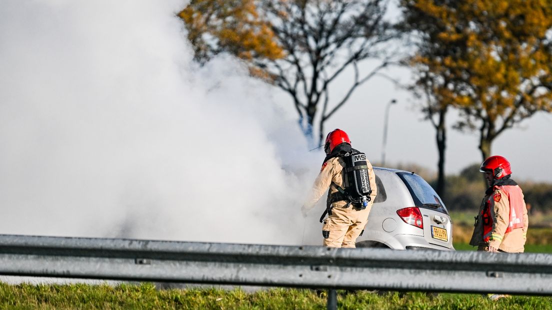 Een auto brandt uit langs de A7 bij Hoogezand