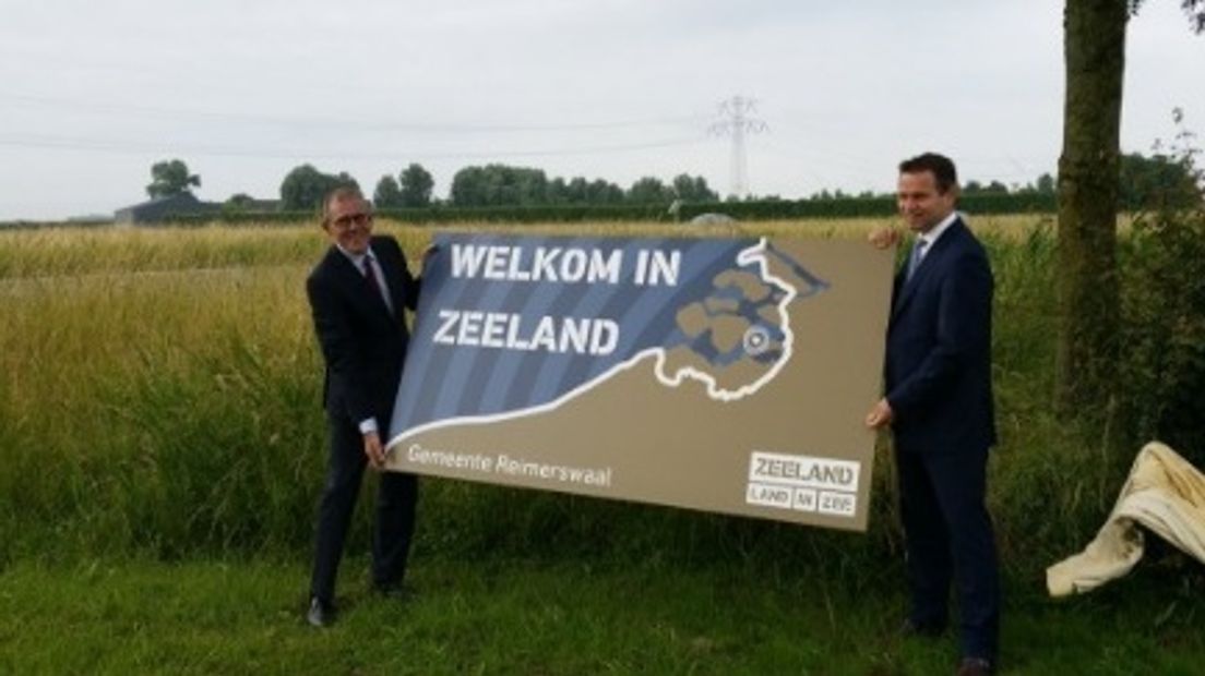 Piet Zoon (links) bij de onthulling van een welkomstbord langs de A58