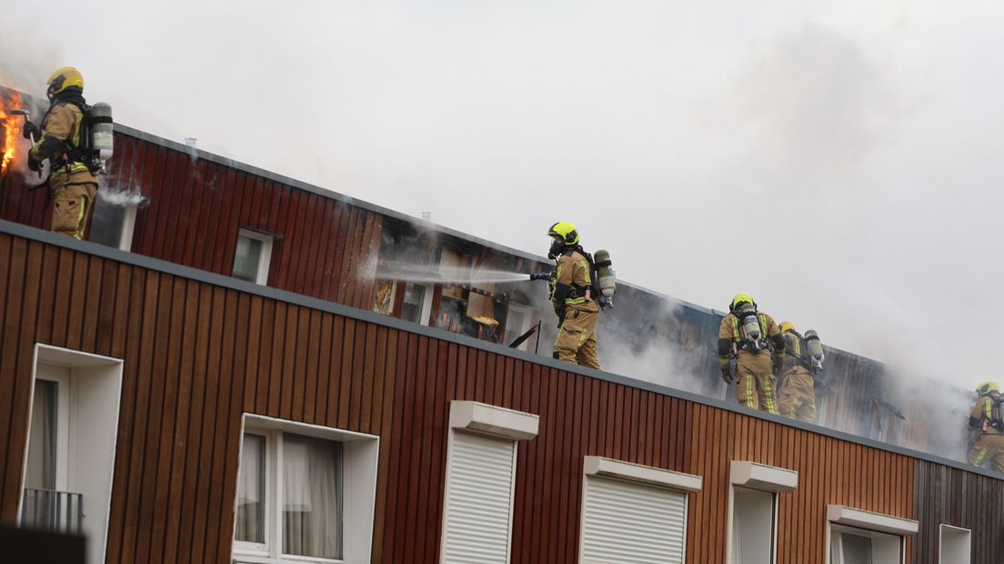 Brandweer op de daken van de woningen aan de Praagsingel