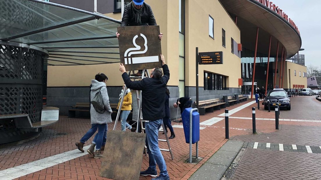 Het bord dat aangeeft waar je bij het UMCG mag roken, wordt symbolisch verwijderd.